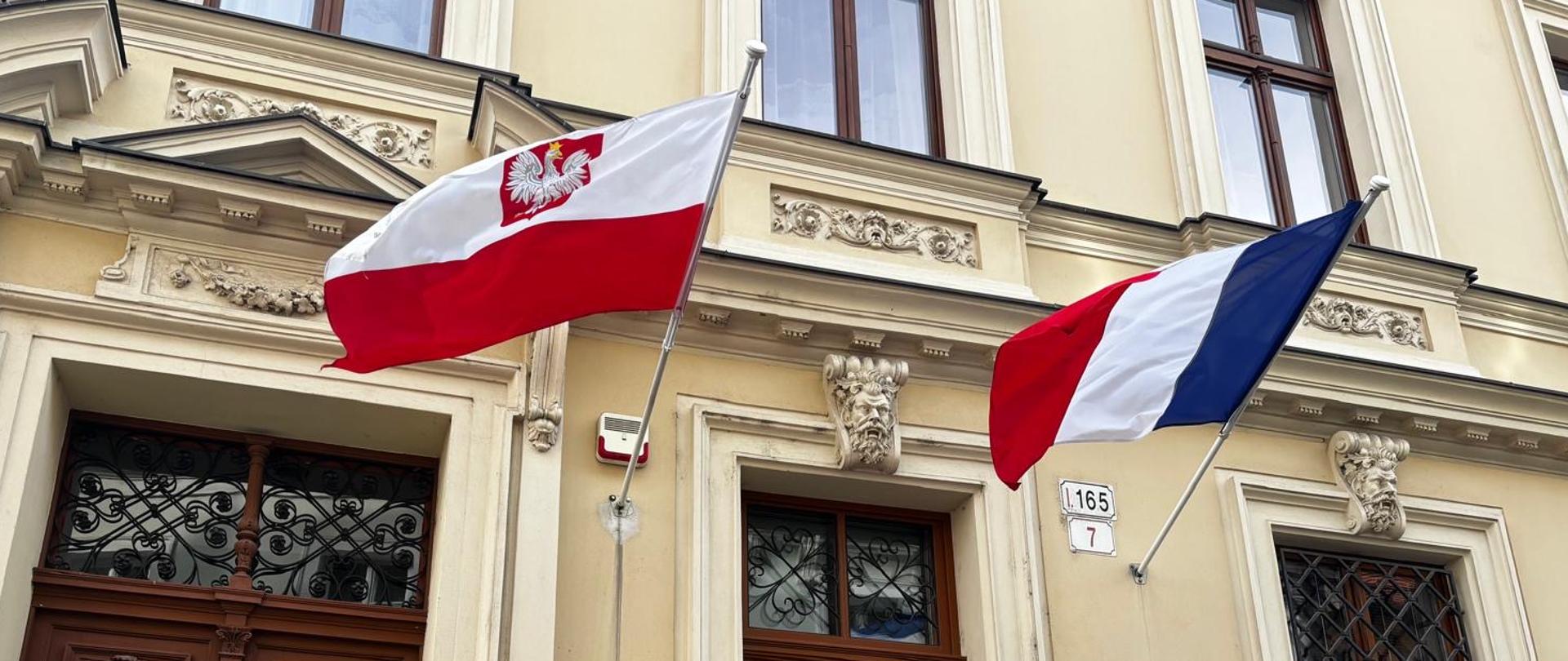 flagi PL i FR wywieszone na budynku Ambasady RP powiewające na wietrze