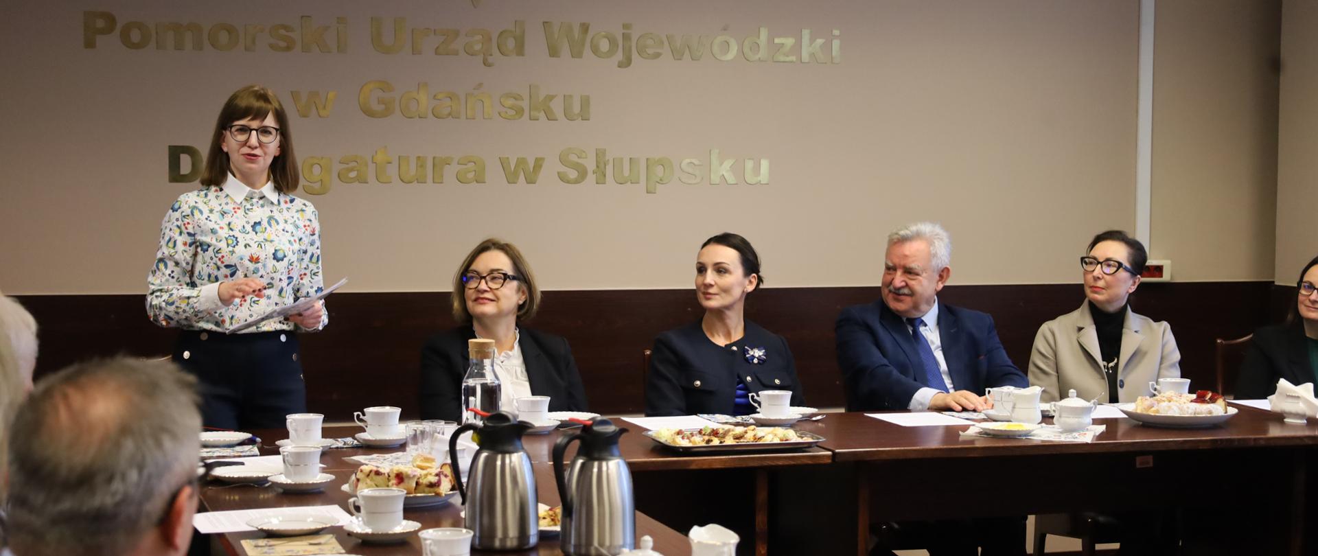 kilka osób siedzi przy stole i rozmawia