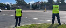 Policjanci za pomocą fotoradaru, stojąc przy drodze, sprawdzają prędkość jadących samochodów