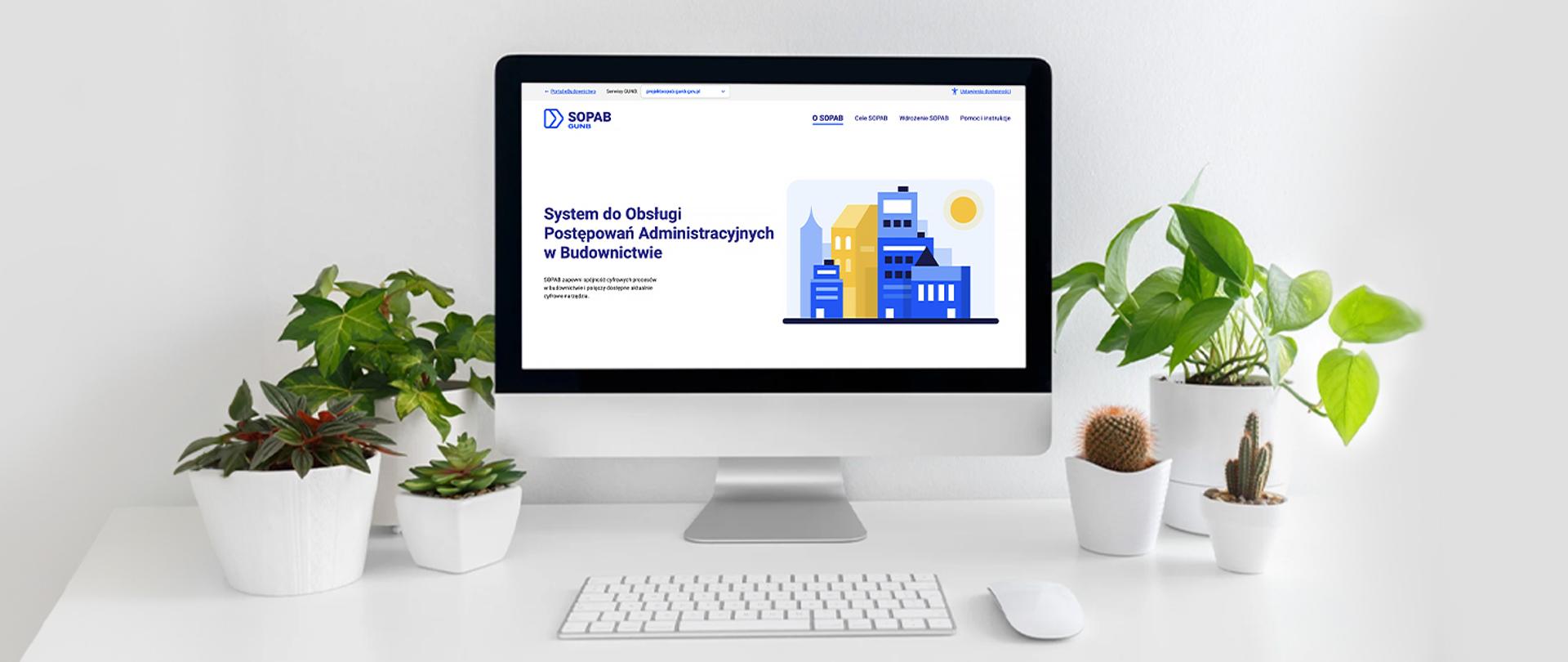 Biurko z komputerem, na monitorze strona internetowa Systemu do Obsługi Postępowań Administracyjnych w Budownictwie. Na ekranie widoczna ilustracja z kolorowymi budynkami. Biurko ozdobione jest kilkoma zielonymi roślinami doniczkowymi i kaktusami ustawionymi po obu stronach monitora. Otoczenie jest jasne, minimalistyczne, z białym tłem.