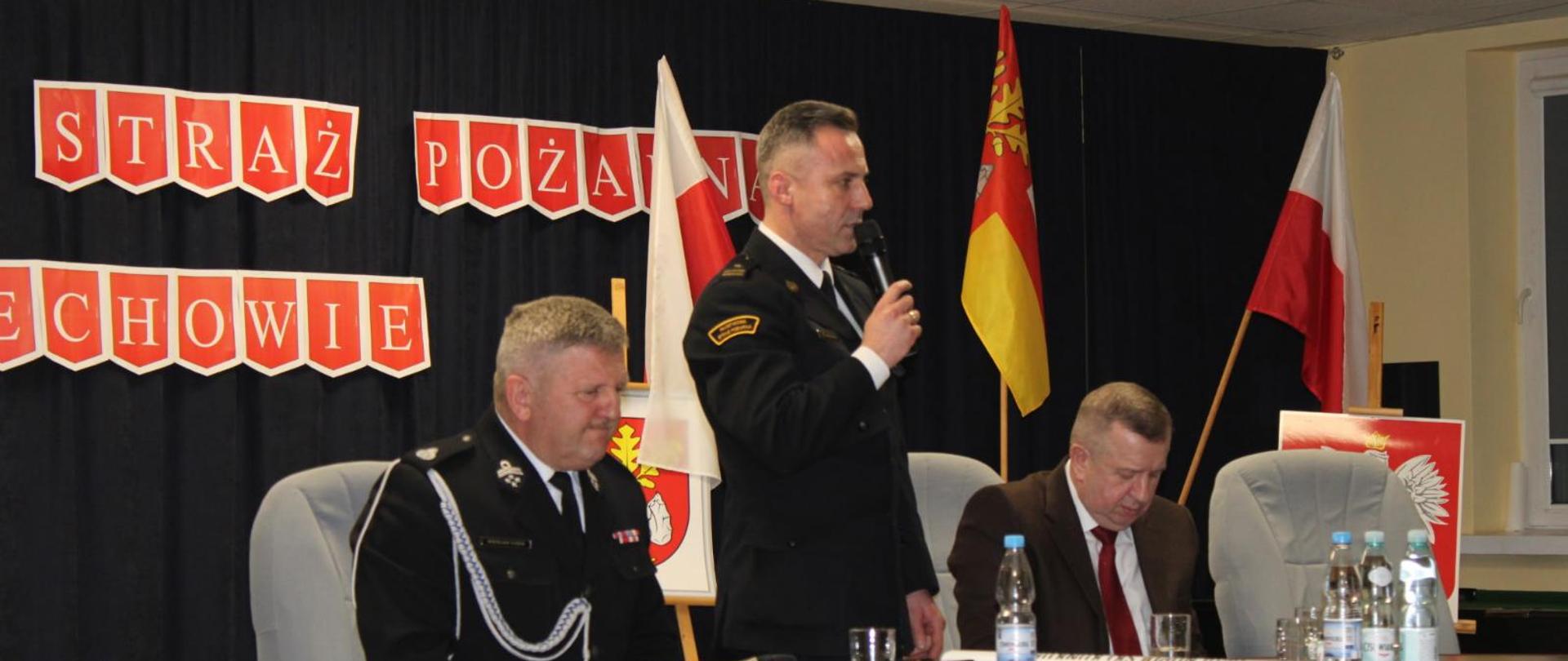 Na zdjęciu widoczny jest Komendant Powiatowy Państwowej Straży Pożarnej w Ostrowcu Św. w trakcie przemowy na zebraniu sprawozdawczo-wyborczym OSP.