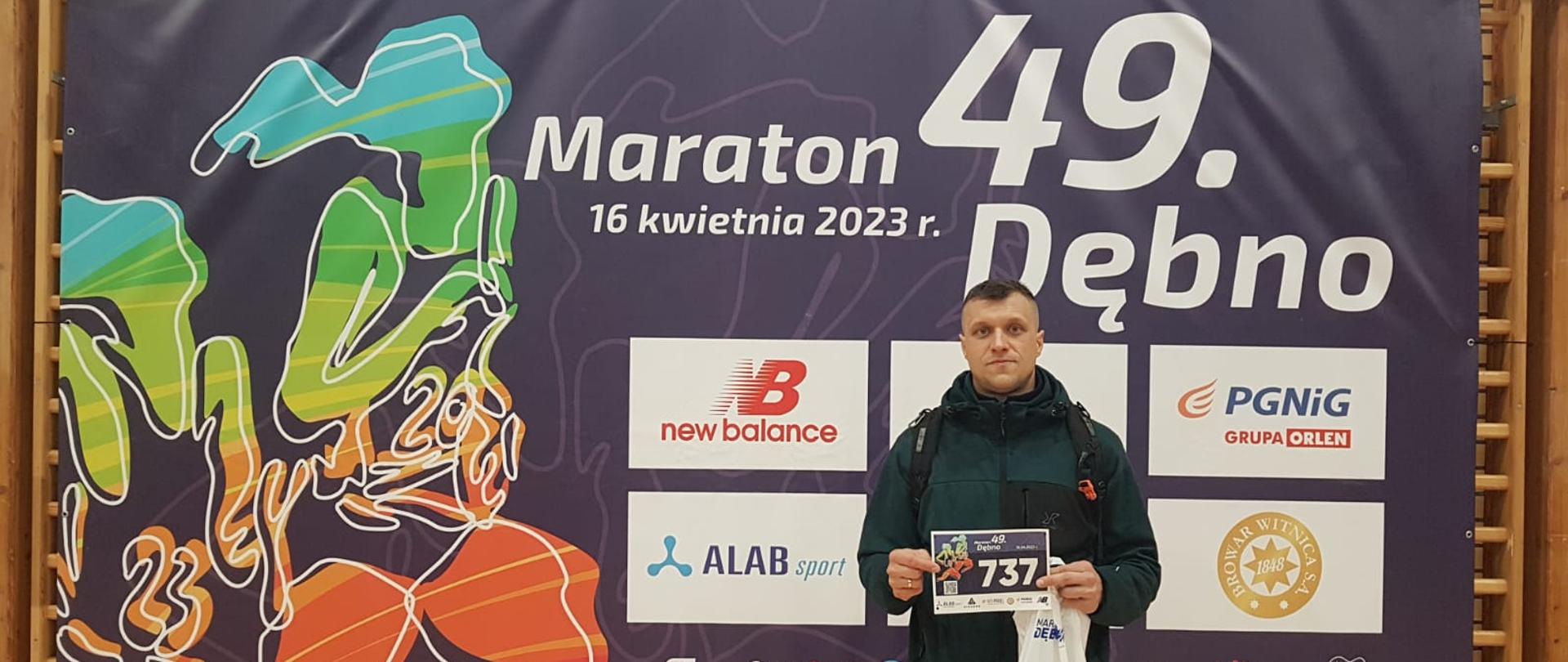 Zdjęcie przedstawia reprezentanta KP PSP w Wałczu z numerem startowym na tle reklamy 49 Dębno Maratonu 