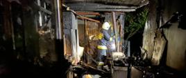 Na zdjęciu widać wnętrze spalonego obiektu oraz strażaka 