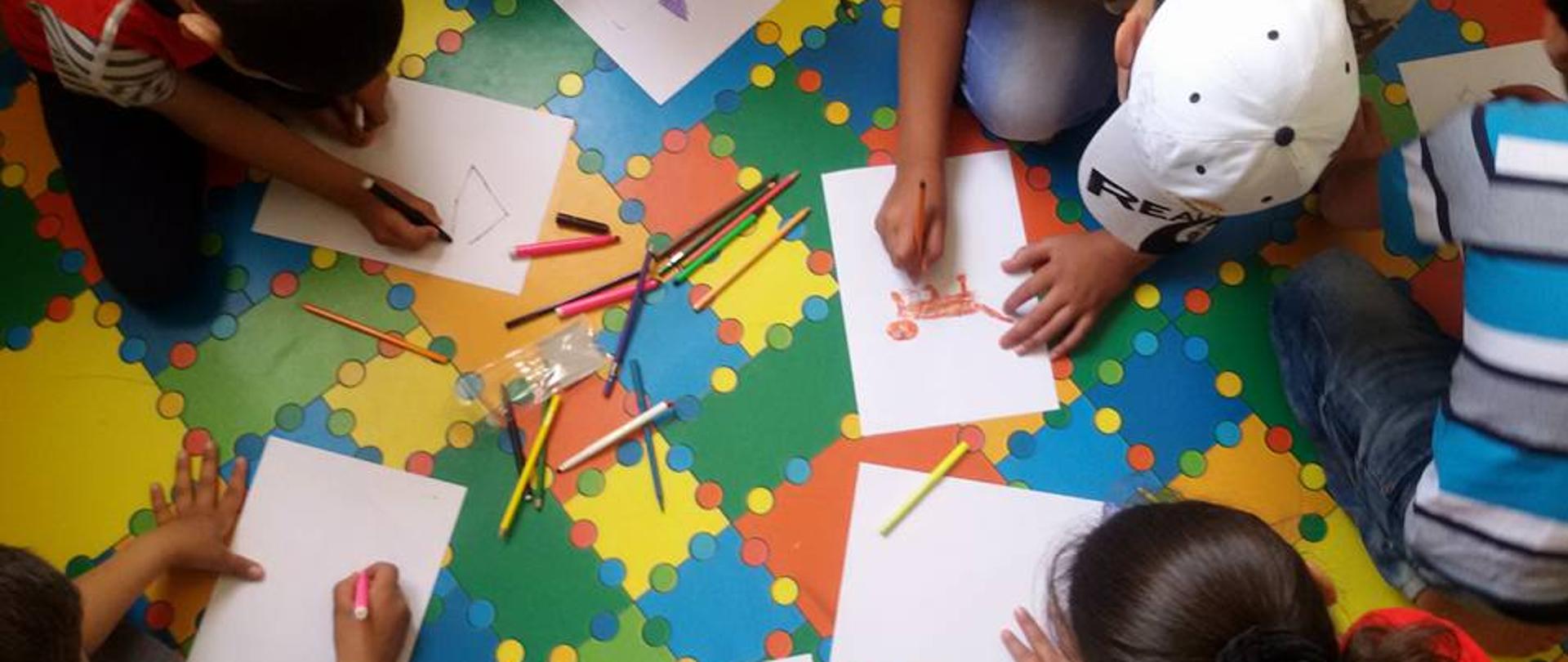 grupa dzieci rysuje obrazki