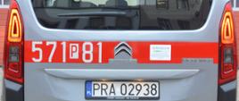 Nowy samochód specjalny. Plac Komendy Powiatowej PSP w Rawiczu, na którym zaparkowany jest nowy nabytek - lekki samochód kwatermistrzowski. Auto ma srebrny kolor. Na karoserii naklejony jest czerwony pas, na którym znajduje się numer 571P81. Widok z tyłu. W tle budynek komendy.