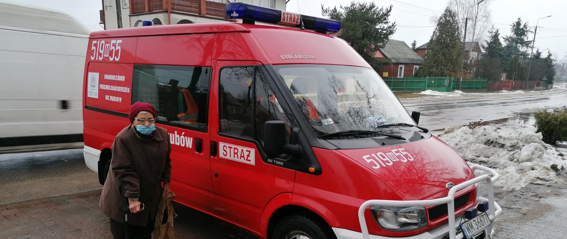 Starsze kobieta przed samochodem strażackim OSP Jakubów