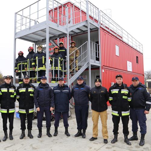 Strażacy na tle trenażera