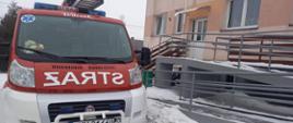 Zdjęcie przedstawia samochód straży pożarnej przed budynkiem przychodni 