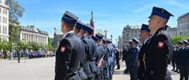 Strażacy ustawieni w pododdział w równych rzędach stoją na placu uroczystości.