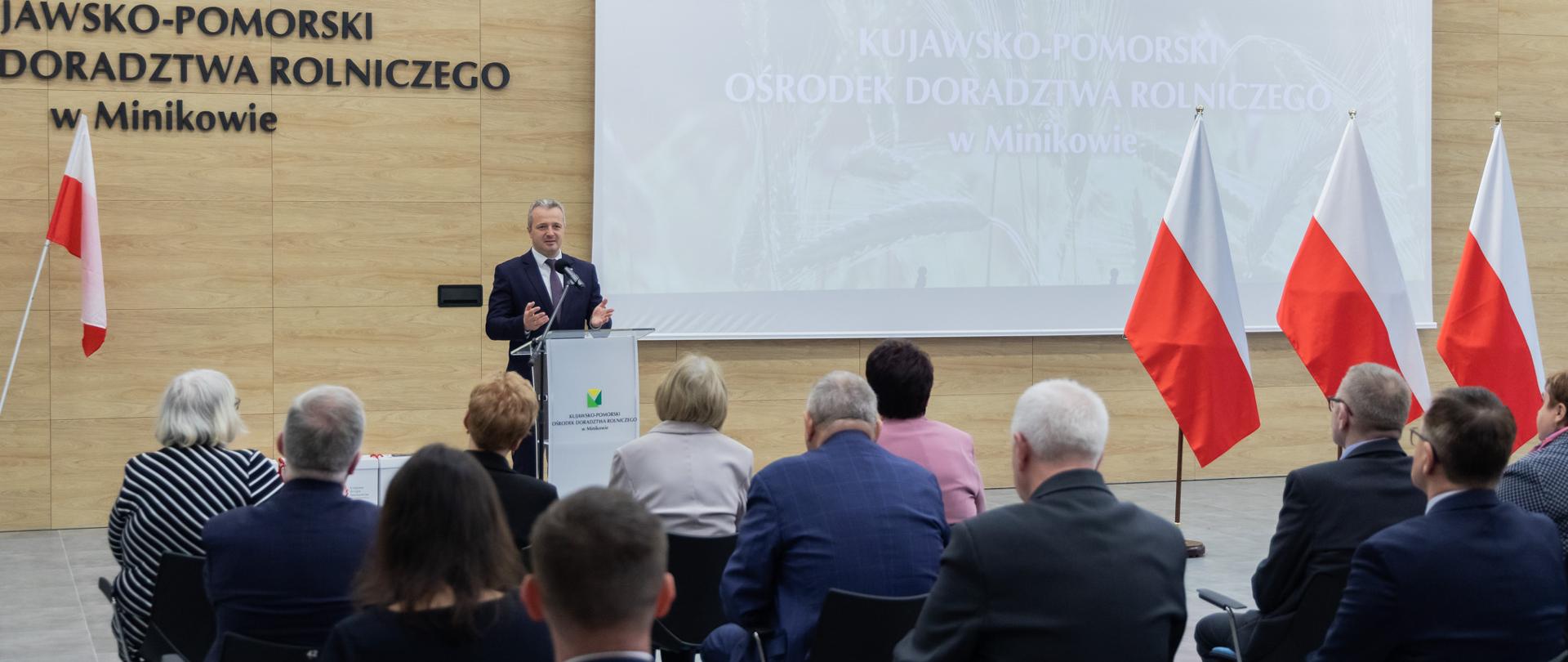 Jeden mężczyzna stojący przy mównicy i wypowiadający się