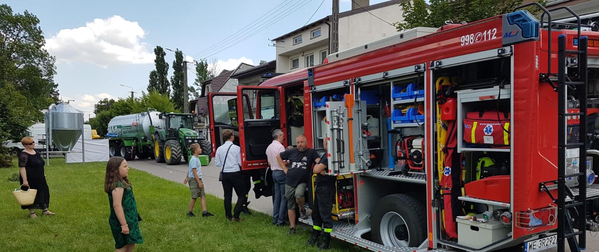Uczestnicy pikniku oglądają samochód pożarniczy