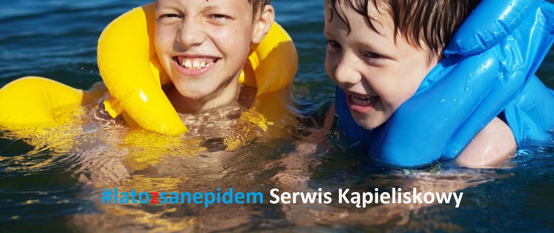 Zdjęcie przedstawia dwójkę kapiących się dzieci w kamizelkach dmuchanych żółtej i niebieskiej