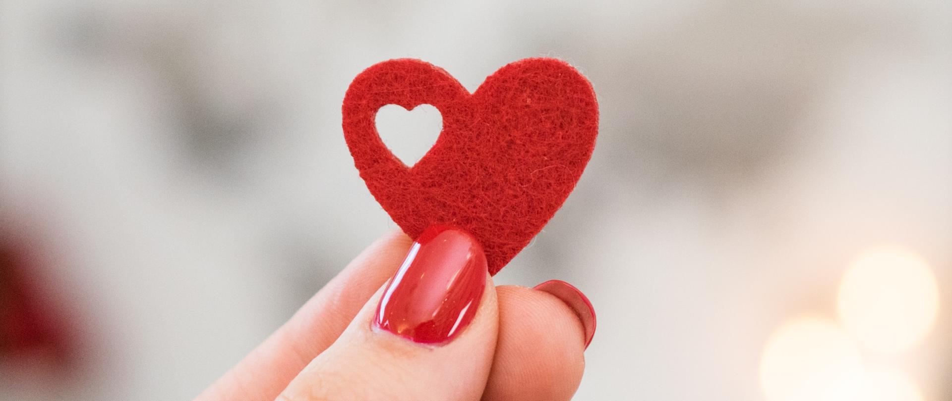 czerwone serduszko trzymane w damskiej dłoni