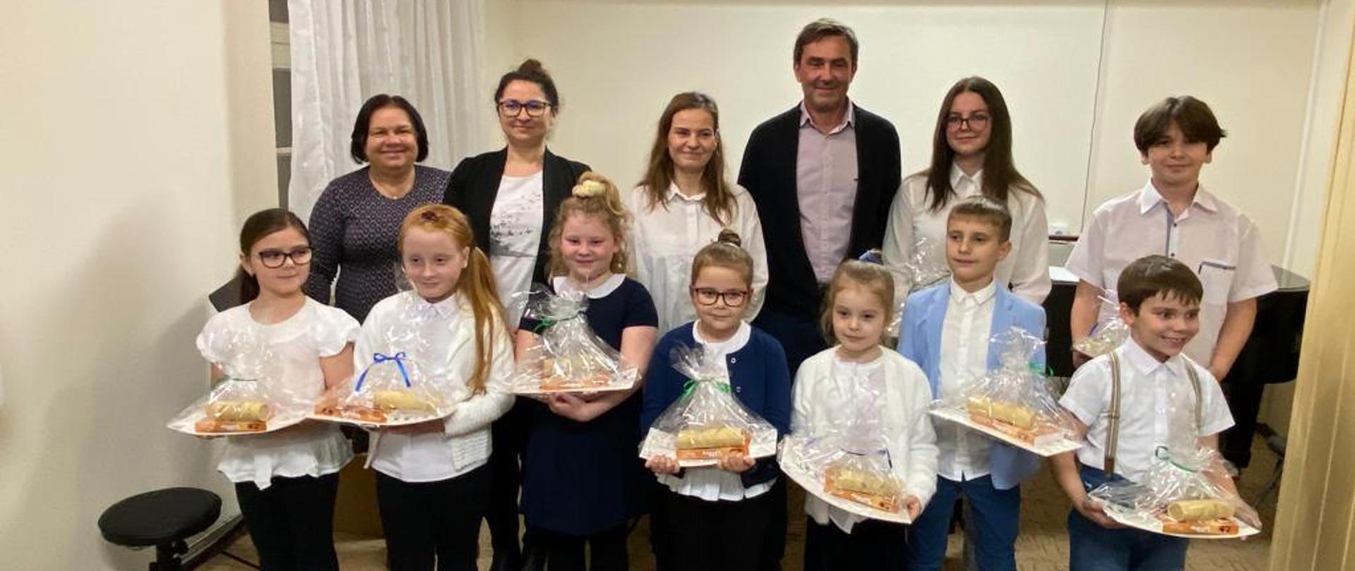 Zdjęcie przedstawia uczniów klas pierwszych oraz przewodniczącą rady rodziców, dyrektora i pedagogów