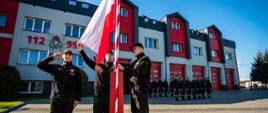 Zdjęcie przedstawia poczet flagowy podczas podnoszenia flagi na maszt, w tle komenda