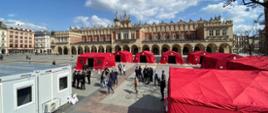 Plac rynku głównego w Krakowie. W centralnej części sukiennice, a przed nimi rozłożone namioty