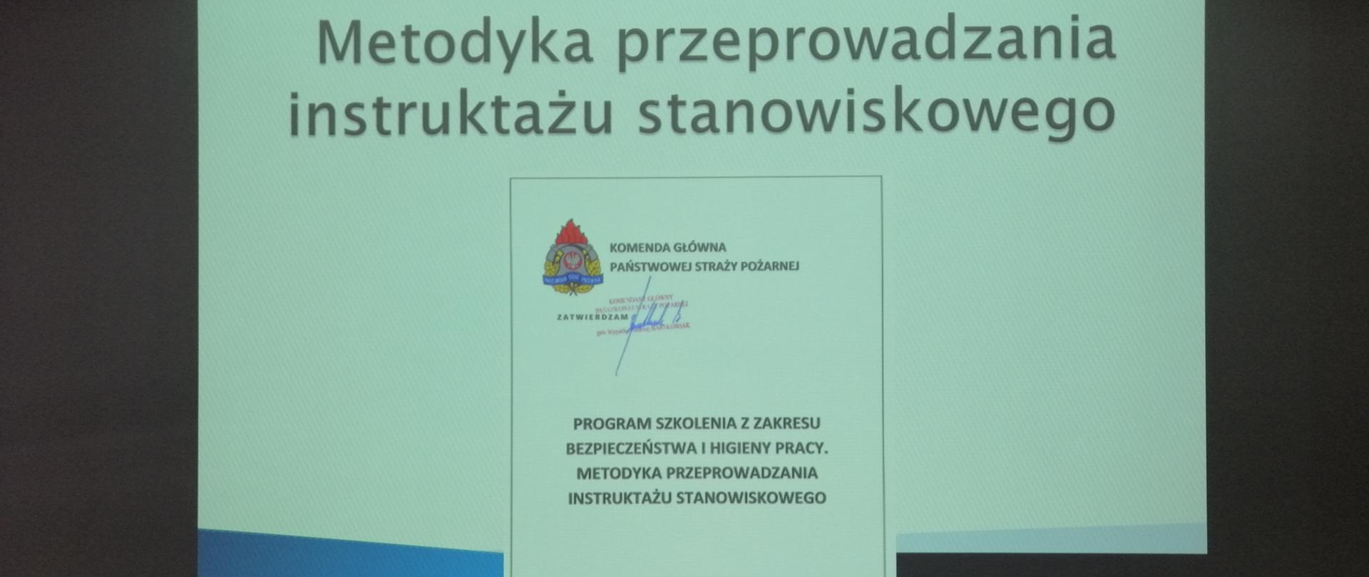 Na zdjęciu widać pierwszy slajd strona tytułowa szkolenia. Slajd wyświetlony jest na ścianie w sali konferencyjnej w budynku KP PSP w Ostrowcu Św.