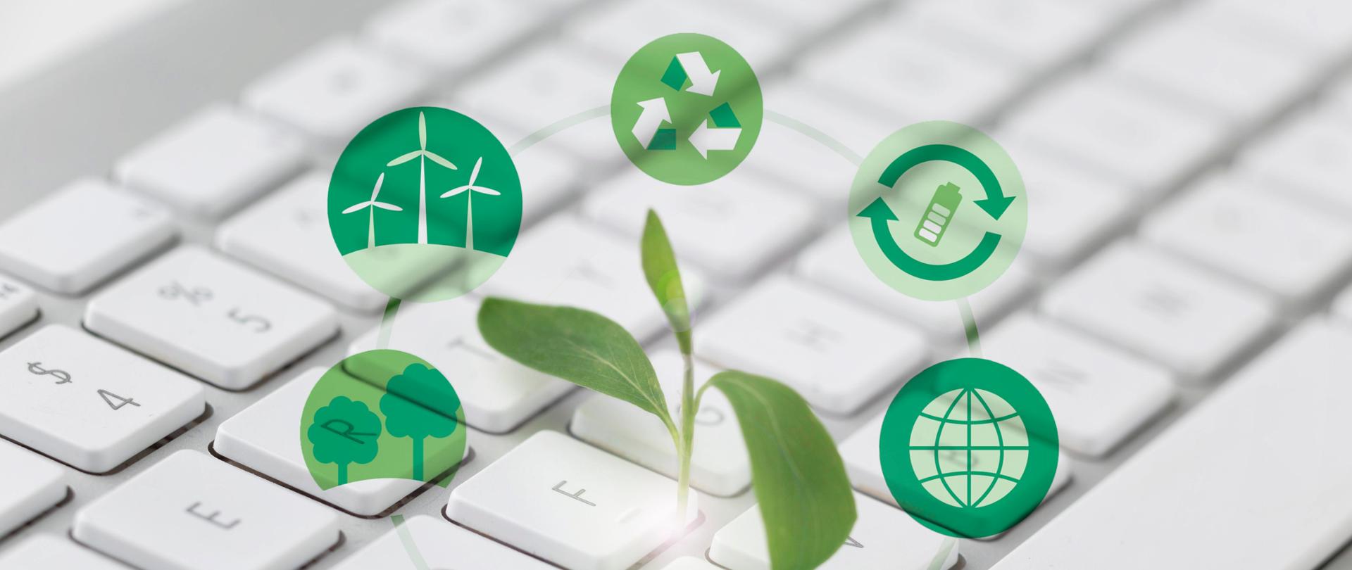 Zdjęcie klawiatury komputera nad nią zielone ikonki symbolizujące odnawialne źródła energii