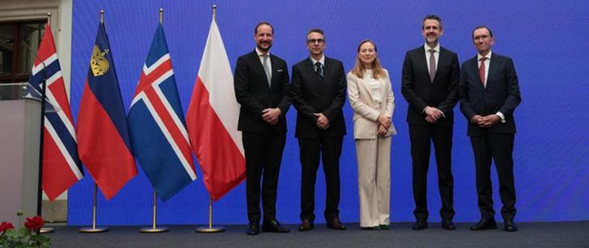 Pictured: Minister Katarzyna Pełczyńska-Nałęcz on stage with other conference participants. The Polish and Norwegian flags are in the background