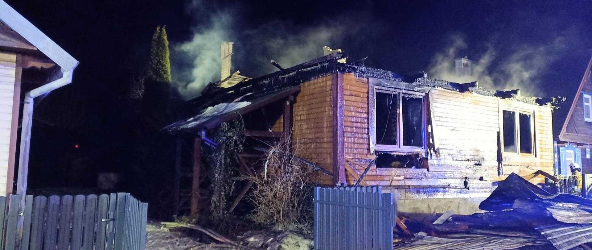 Strażacy podczas działań związanych z pożarem budynku jednorodzinnego