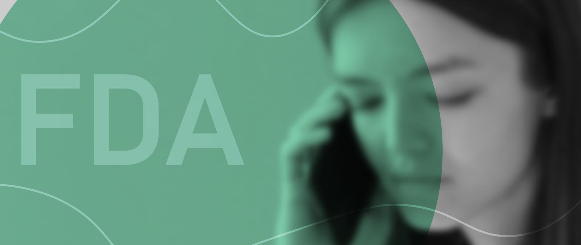 Zdjęcie przedstawia kobietę trzymającą telefon komórkowy przy uchu za kolorowym tłem i napisem "FDA".