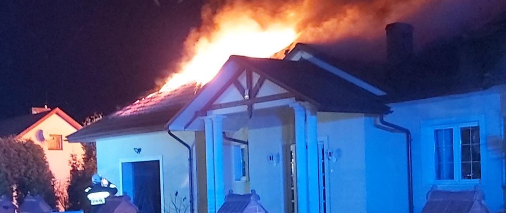 Pora nocna. Płonący dach na budynku parterowym.