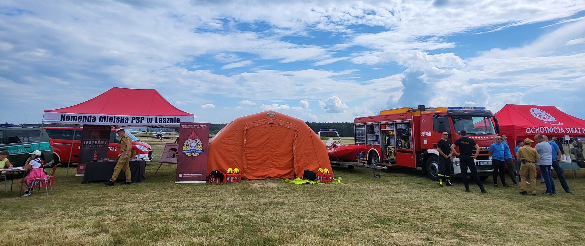 Sprzęt strażacki rozstawiony na płycie lotniska.