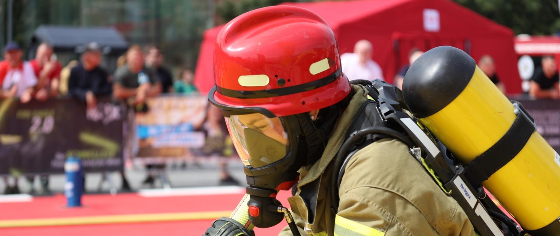 Na zdjęciu znajduje się strażak, który biegnie w zawodach FireFit.