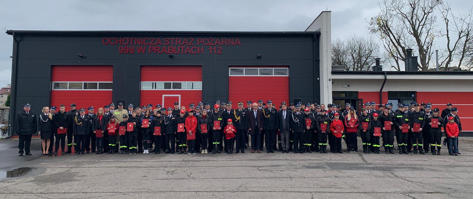 Grupowe zdjęcie (na tle remizy OSP Prabuty) wszystkich gości, członków MDP oraz ich opiekunów