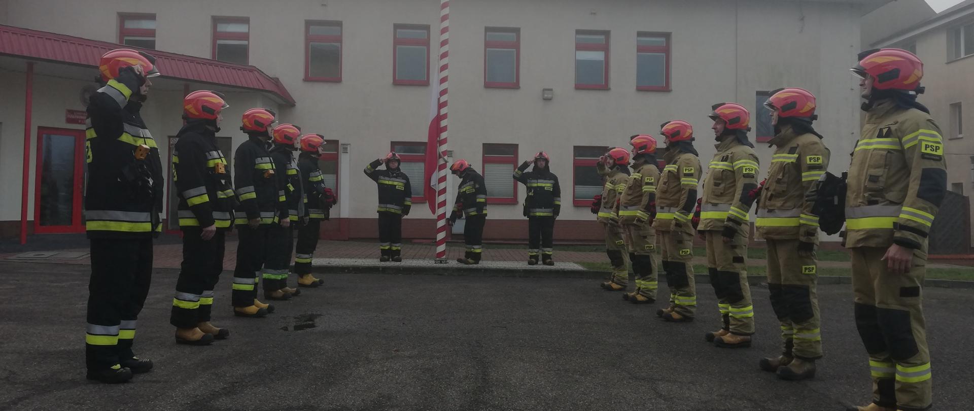 Na placu KP PSP w Człuchowie odbywa się uroczysta zmiana służby, w trakcie której podniesiono flagę państwową na maszt przy akompaniamencie Mazurka Dąbrowskiego.