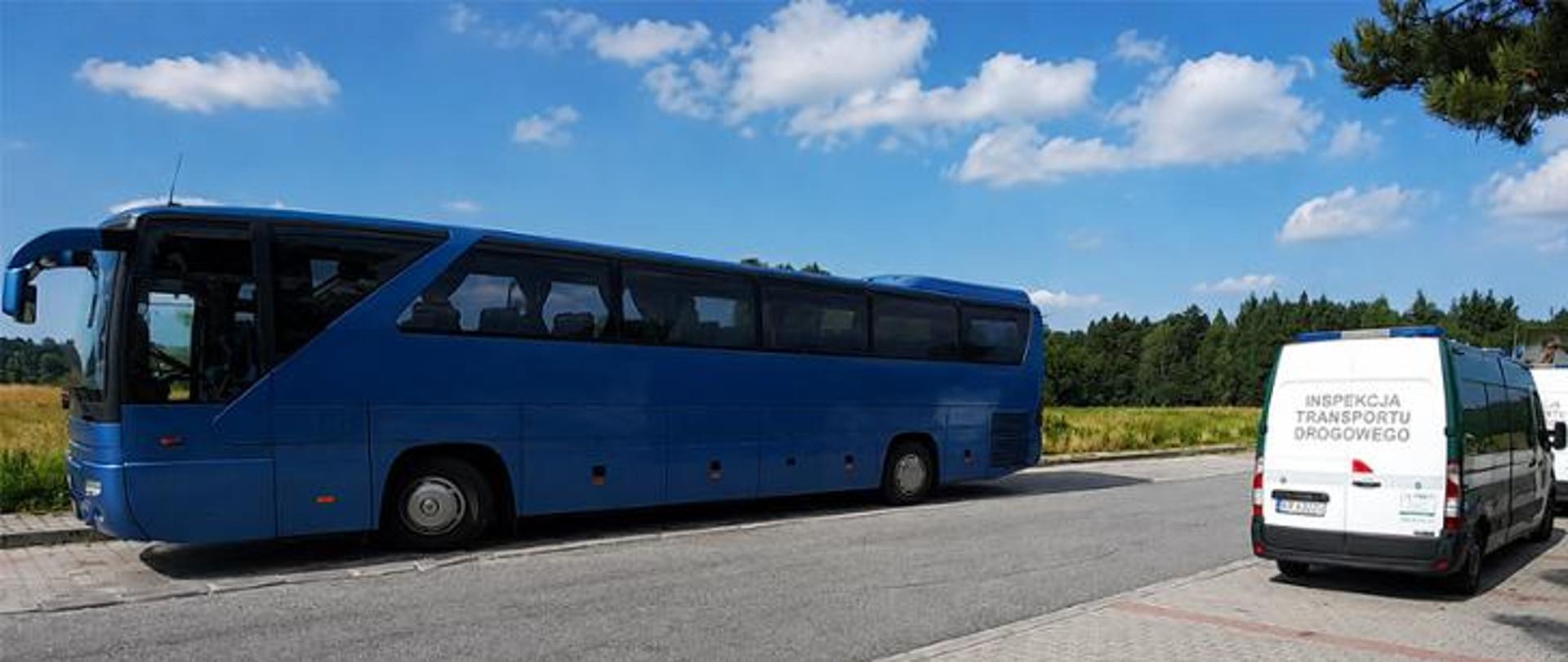 Zatrzymany do kontroli niebeieski autokar turystyczny. Obok stoi oznakowany radiowóz ITD.