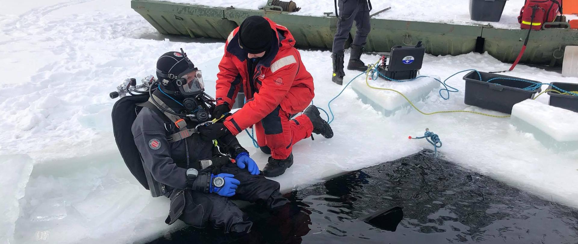 Strażak sprawdza nurka przed zanurzeniem pod lodem