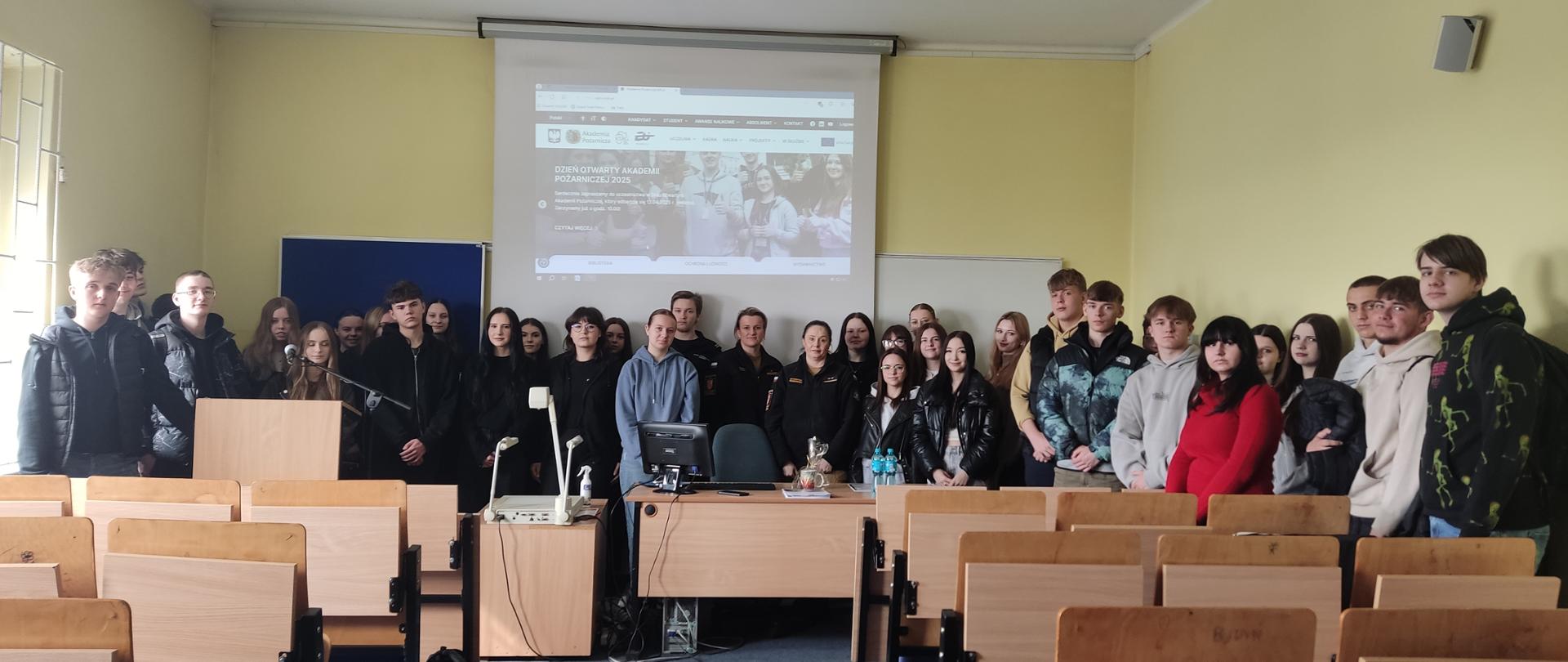 Zdjęcie przedstawia uczniów i funkcjonariuszki podczas spotkania dotyczącego propagowania zawodu oficera w ramach TYGODNIA MUNDUROWEGO 2025