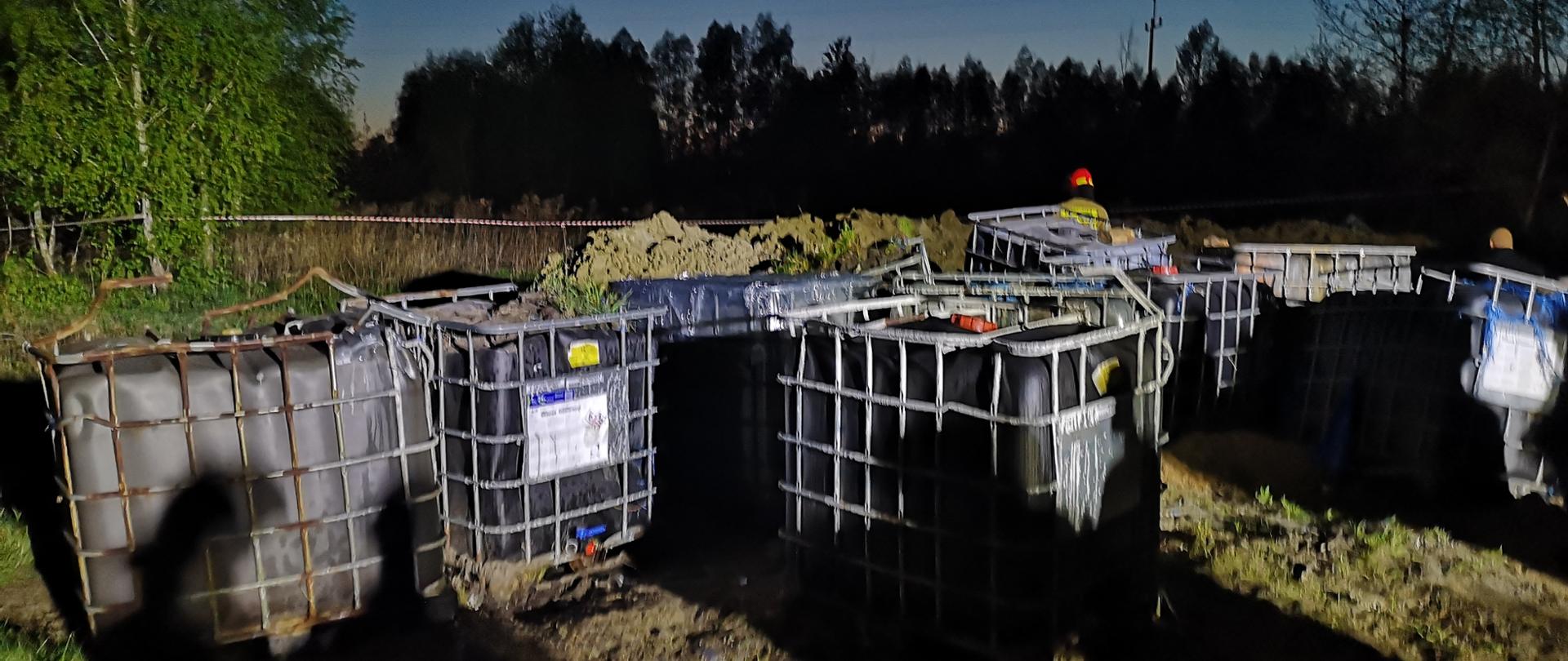 Kilkanaście pojemników o pojemności 1000 l stojących na otwartym terenie.