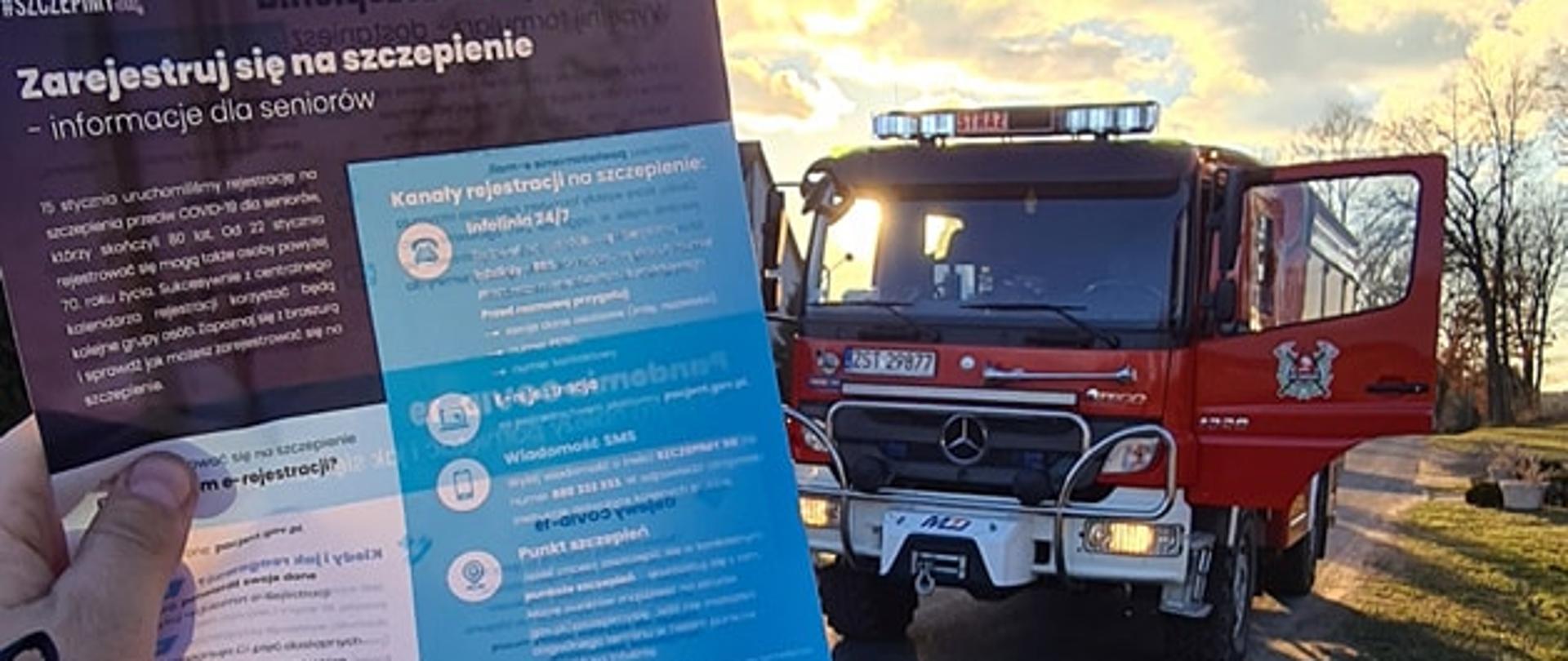 ulotka w ręku strażaka OSP, w tle pojazd gaśniczy