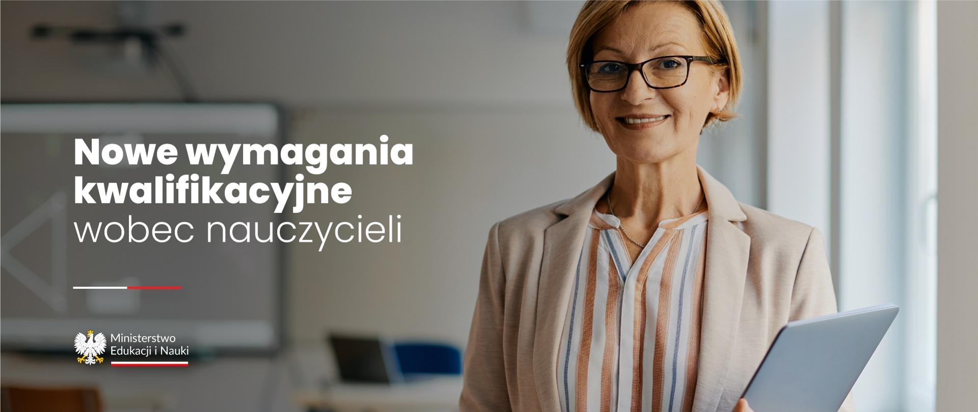 Nauczycielka stoi w szkolnej klasie, trzyma w ręku dziennik, obok napis Nowe wymagania kwalifikacyjne wobec nauczycieli.