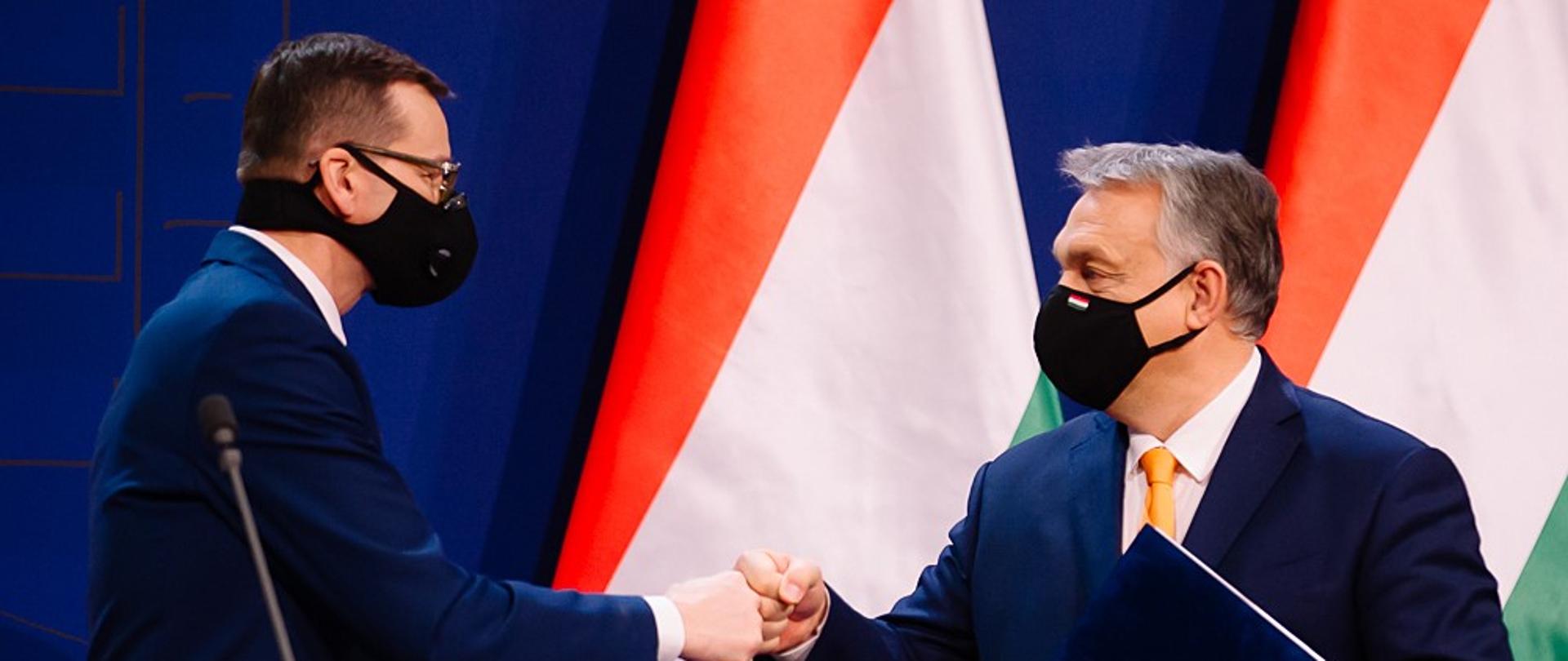 Premierzy Polski i Węgier przybijają sobie żółwika.