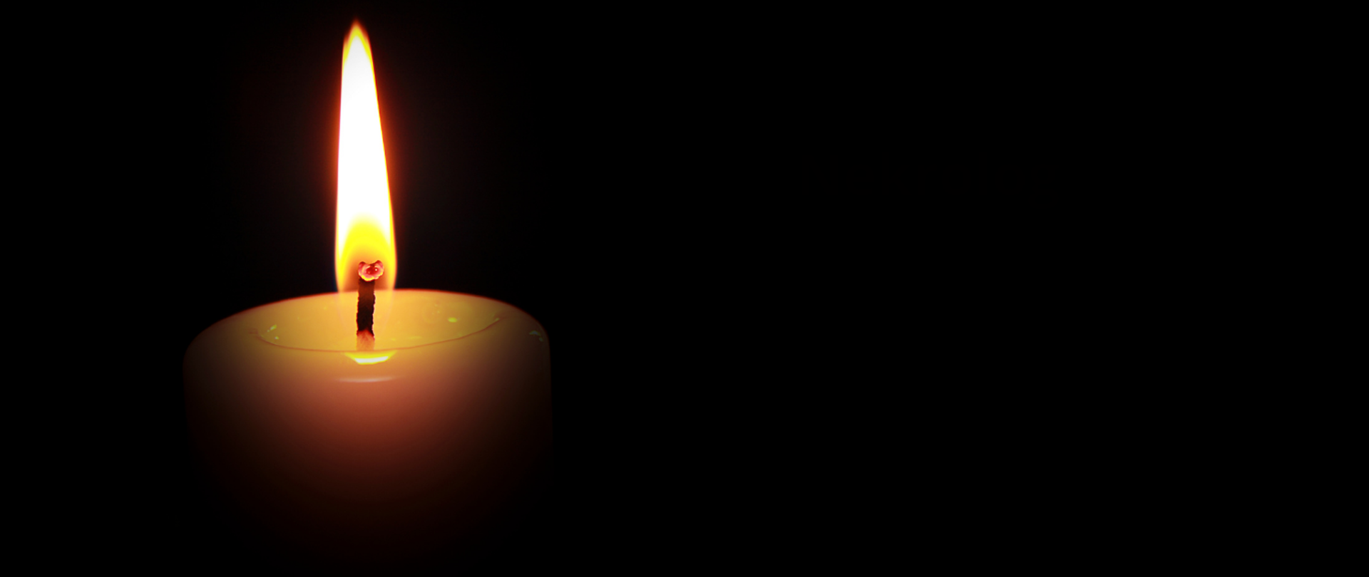 Na czarnym tle z lewej strony płonąca świeca.