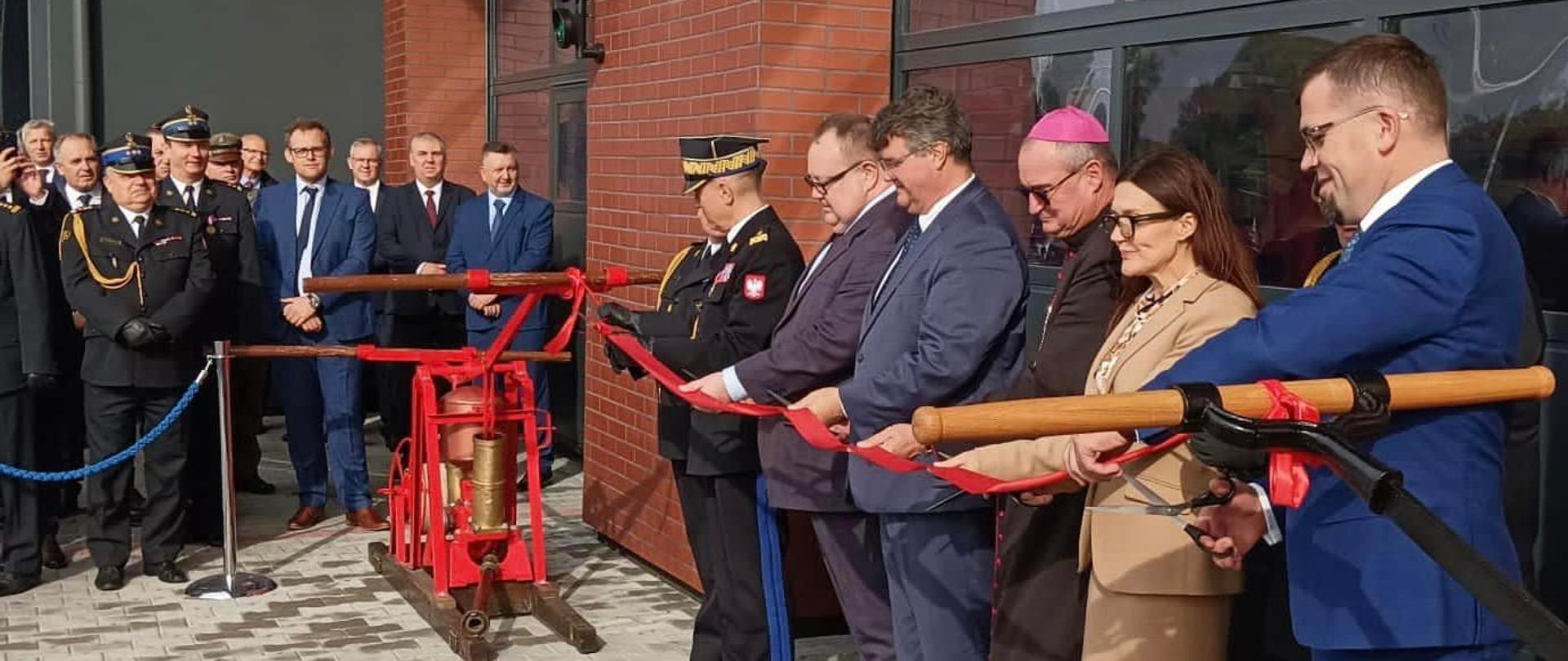 Grupa osób stojąca w szeregu przecina wstęgę.