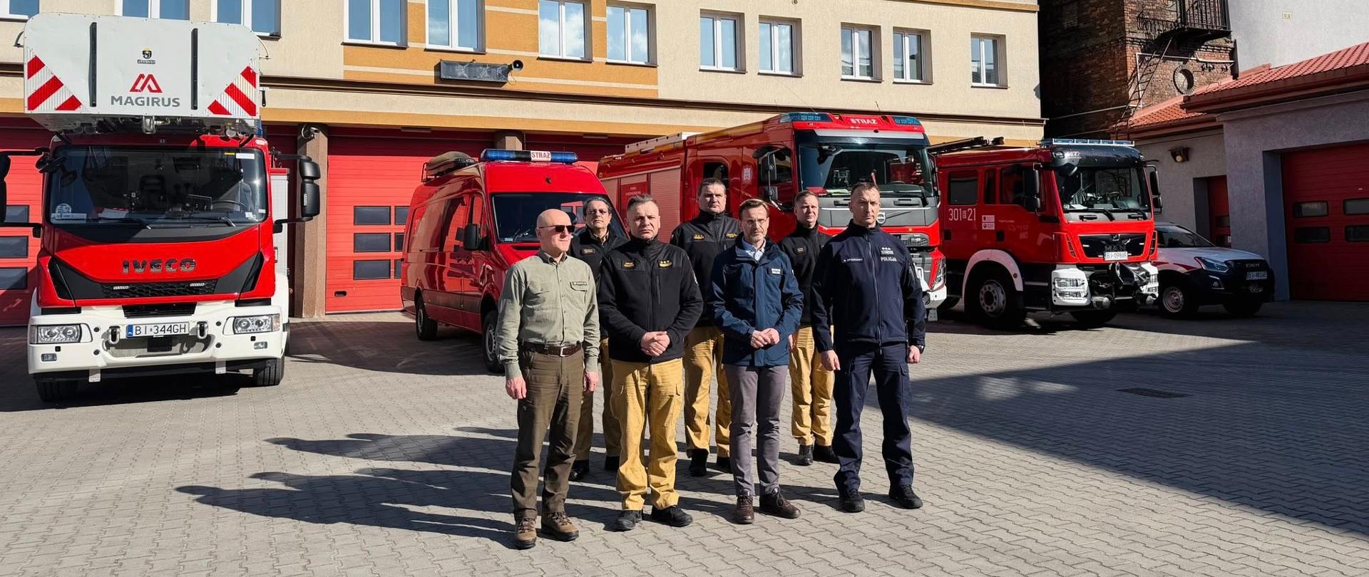 Inauguracja kampanii edukacyjno-informacyjnej pod hasłem "Stop Pożarom Traw" na terenie województwa podlaskiego - uczestnicy spotkania na tle samochodów pożarniczych