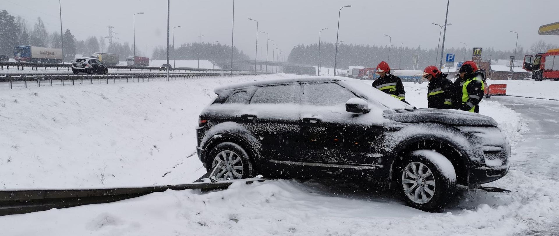 Widok na samochód marki Land Rovera, który uderzył i zawiśł na barierach energochłonnych