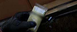 Ręka w skórzanej czarnej rękawiczce trzyma otwartą paczkę papierosów.