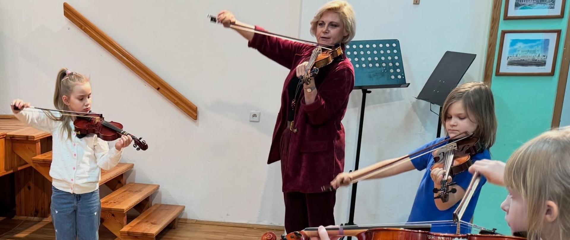 Zdjęcie przedstawiające uczestników warsztatów skrzypcowych z Małgorzatą Wacławik, która odbyły się w auli szkoły, 19 lutego 2026 roku.