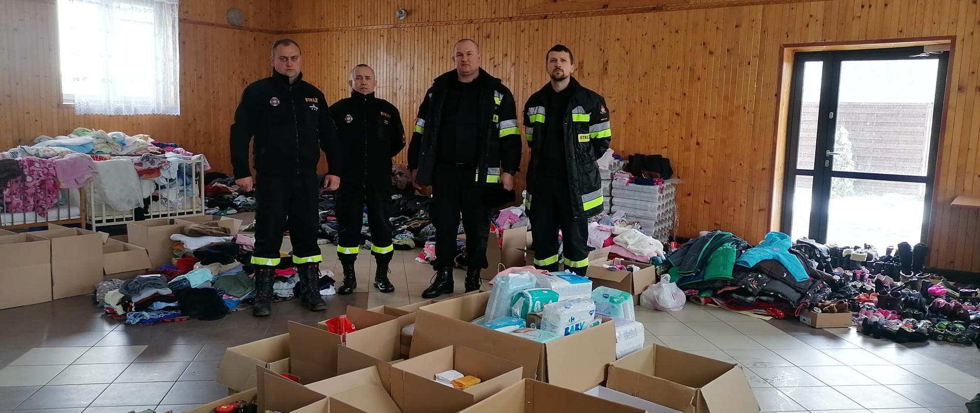 Na zdjęciu Zastępca Komendanta wraz z funkcjonariuszem KP PSP Mińsk Mazowiecki oraz Prezes i Wiceprezes OSP Żaków w magazynie z darami dla uchodźców z Ukrainy