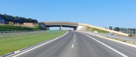 Droga ekspresowa S7 na odcinku Moczydło - Miechów tuż przed udostępnieniem do ruchu. Na zdjęciu dwie jezdnie drogi ekspresowej po dwa pasy ruchu w każdym kierunku. Trwają prace wykończeniowe.