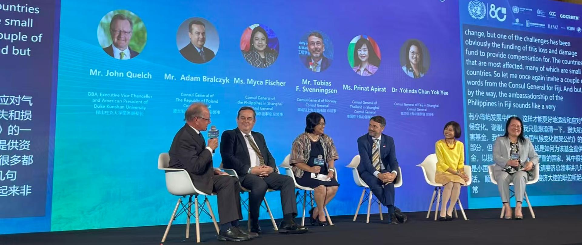 6 osób siedzi na scenie i rozmawia