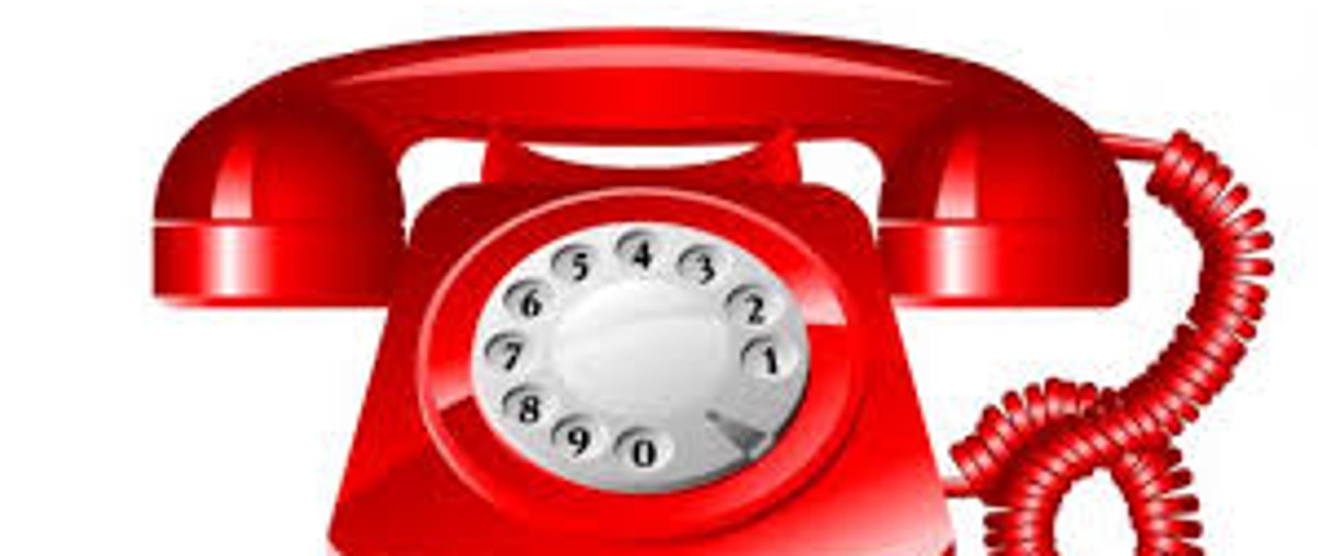 Czerwony telefon na białym tle. Telefon ma biały cyferblat do wykręcania numerów słuchawkę i przewód