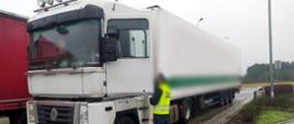 Pojazd członowy zatrzymany do kontroli przez kujawsko-pomorską Inspekcję Transportu Drogowego. Na zdjęciu jedna ze skontrolowanych ciężarówek na przydrożnym parkingu. Obok pojazdu stoi inspektor ITD, który rozmawia z kierowcą.