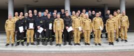 Grupowe zdjęcie uczestników warsztatów (27 osób) w towarzystwie Zastępcy Komendanta Centralnej Szkoły PSP oraz pięciu oficerów CS PSP