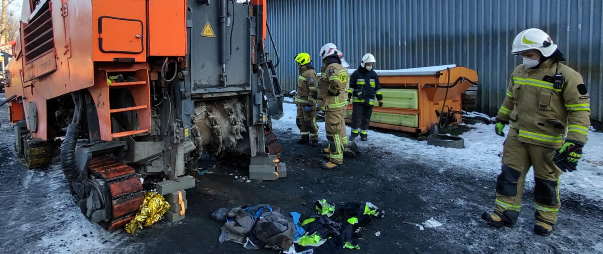Maszyna a obok niej strażacy
